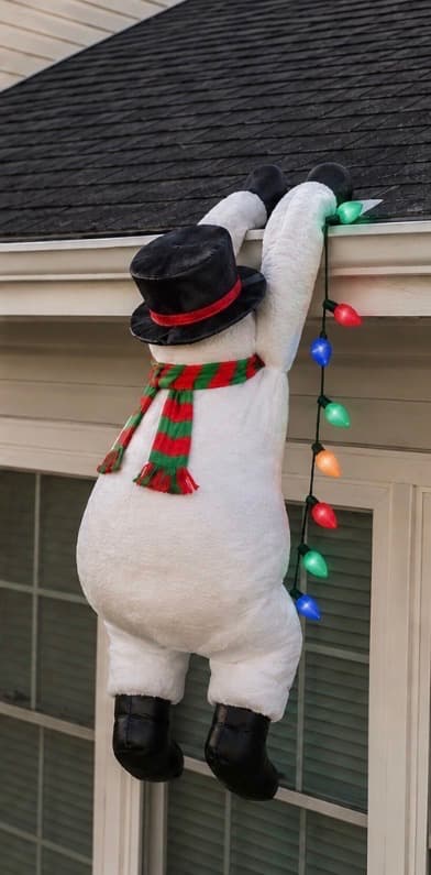 Snowman ROOFMAS hanging from a roofline